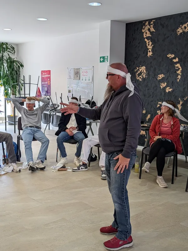 Michael Busse übt mit den Teilnehmern im Erste-Hilfe-Kurs den Kopfverband