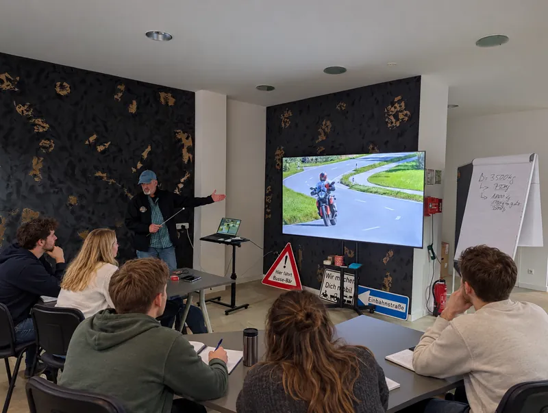 Theorieunterricht in der Fahrschule Busse-Bär: Der Fahrlehrer erklärt am Bildschirm das Kurvenfahren mit dem Motorrad